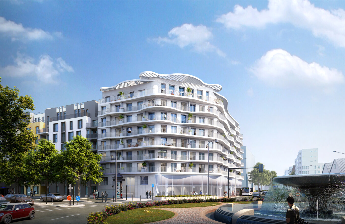 Résidence L’Ove à Courbevoie vue depuis le rond-point : la façade ondulante marque l’entrée du Village Delage, fontaine et plantations au premier plan.