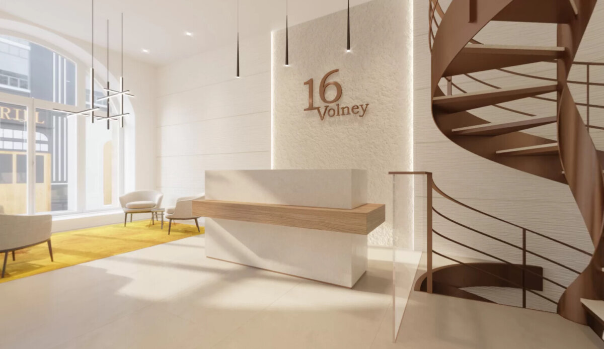 Le hall du 16 rue Volney à Paris : banque d’accueil, signalétique en bronze et escalier hélicoïdal